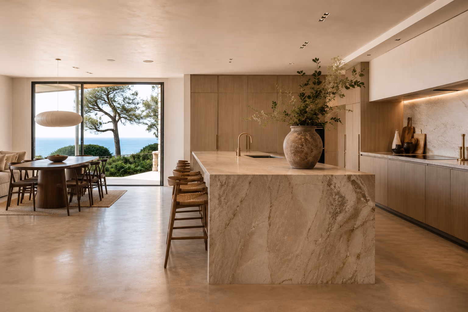 Perspective de la cuisine ouverte sur la salle à manger, sol en béton ciré continu — Résidence Côte d'Or